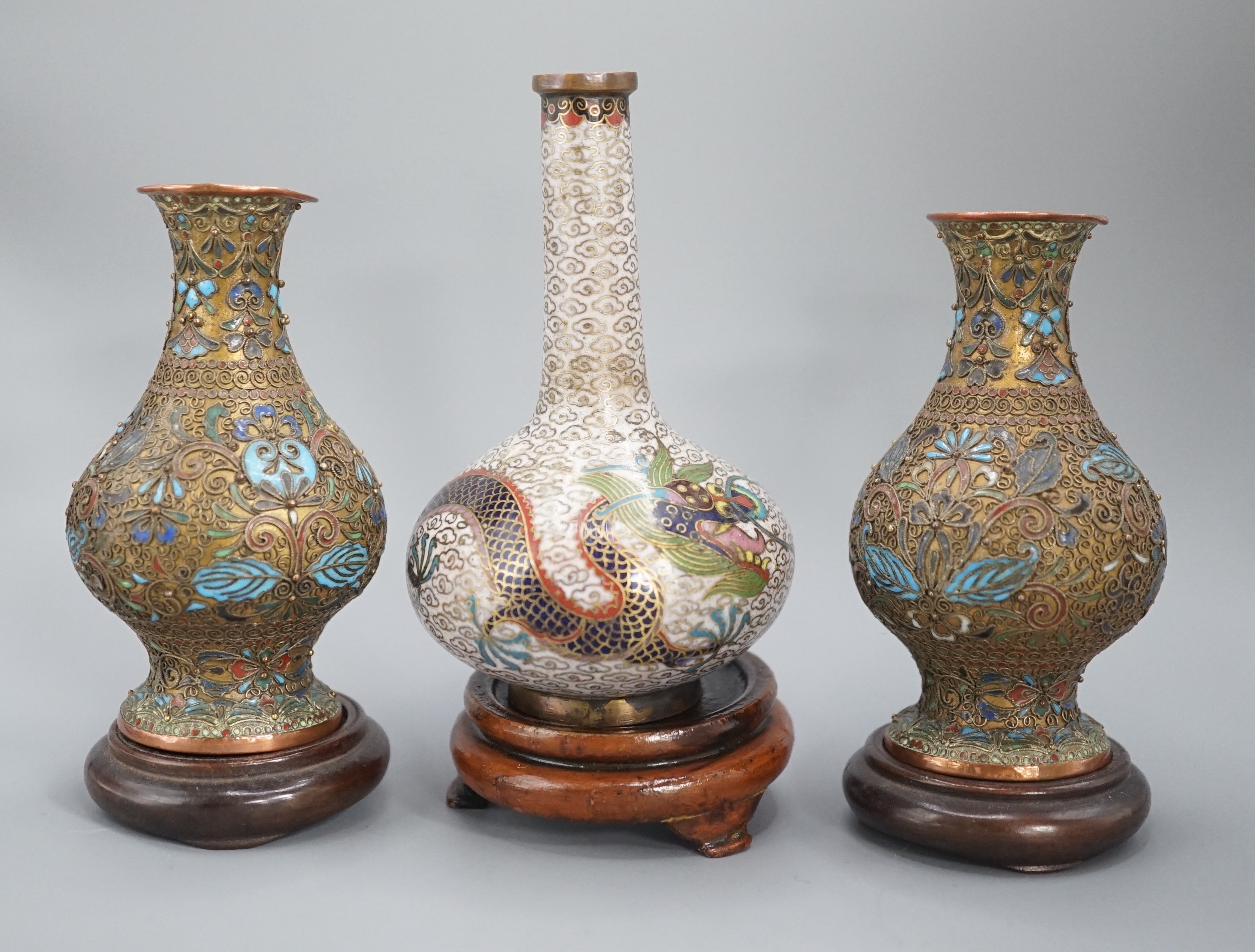 A Chinese cloisonne enamel ‘dragon’ bottle vase, early 20th century and a pair of Japanese cloisonne enamel vases with wood stands 10.5cm